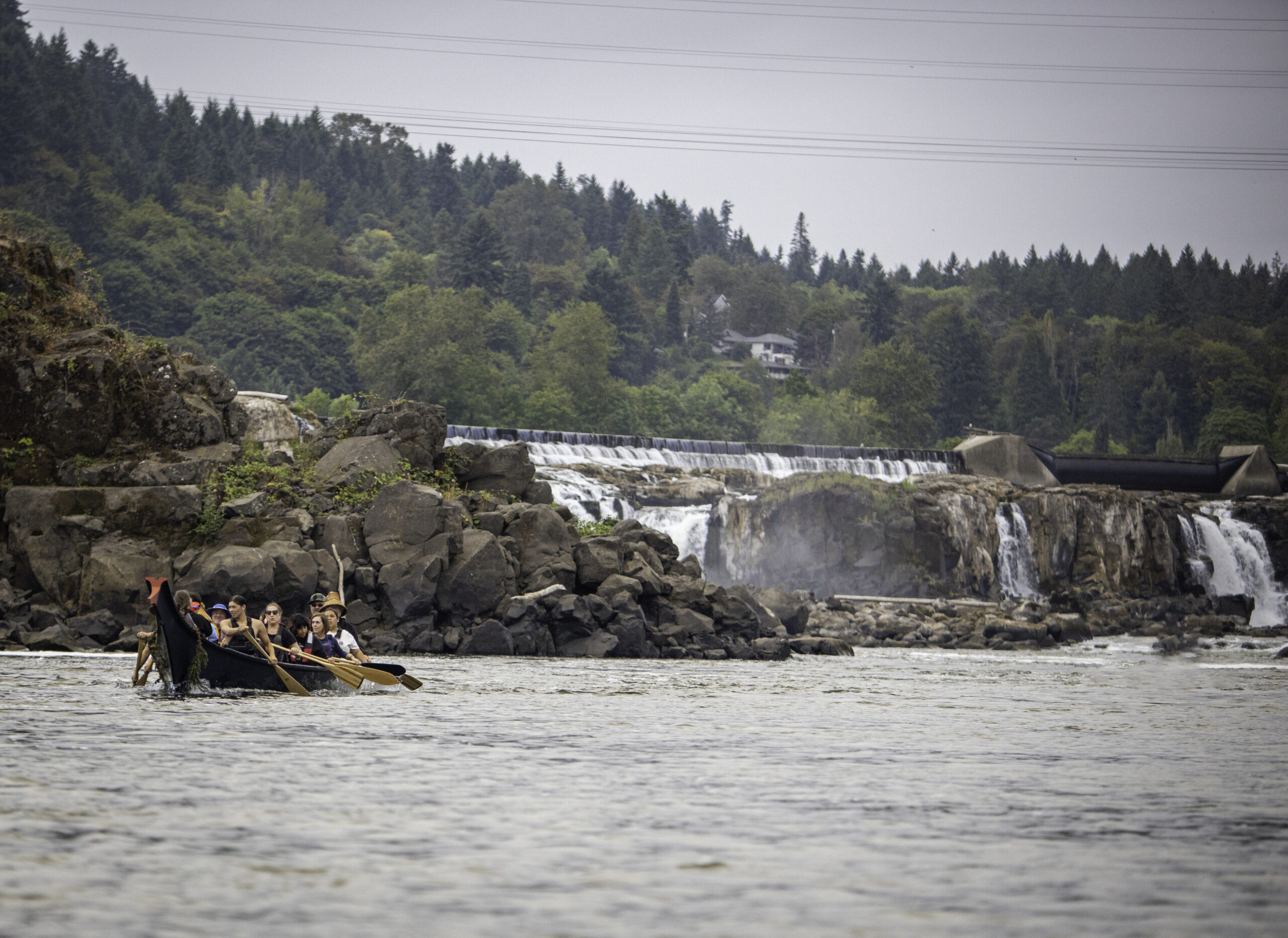 Members of the Confederated Tribes of Grand Ronde paddle a traditional canoe at Willamette Falls.
